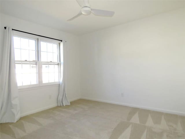 spare room with ceiling fan and light carpet