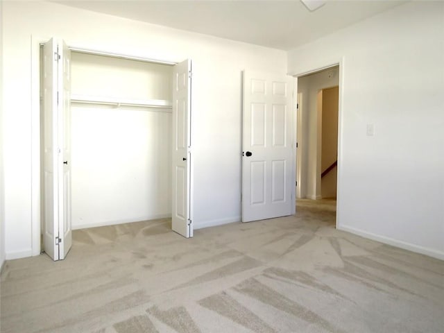 unfurnished bedroom featuring a closet and light colored carpet