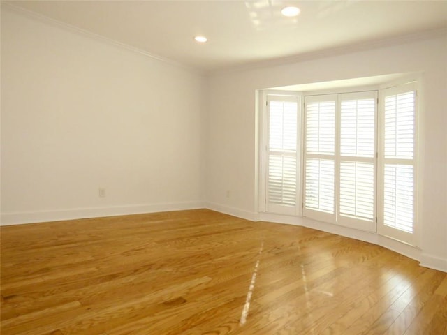 unfurnished room featuring hardwood / wood-style floors and ornamental molding