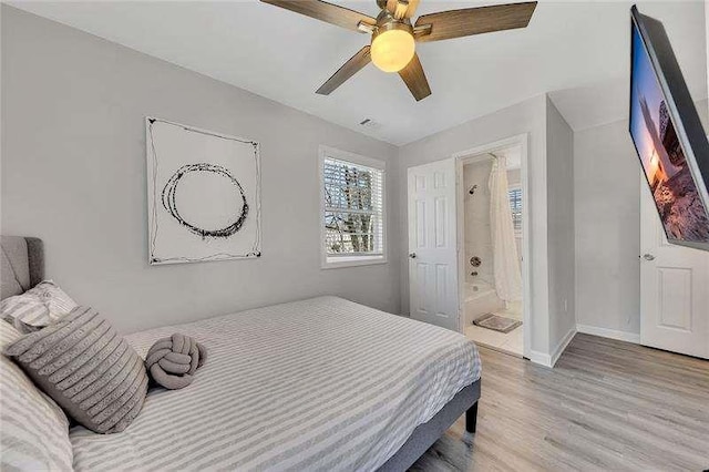 bedroom featuring light hardwood / wood-style flooring, ceiling fan, and ensuite bathroom