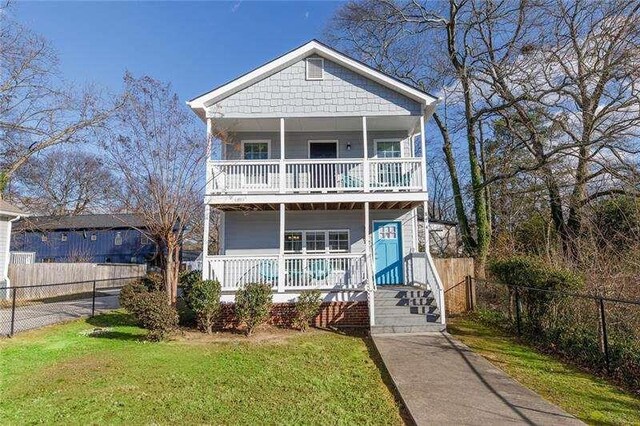 view of front of house with a porch, a balcony, and a front lawn