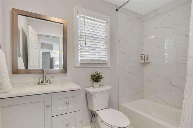 full bathroom featuring tiled shower / bath, vanity, and toilet