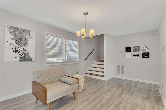 sitting room with an inviting chandelier and light hardwood / wood-style floors