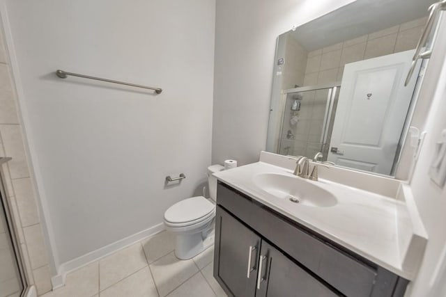 bathroom with tile patterned flooring, walk in shower, toilet, and vanity