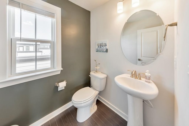 bathroom with a healthy amount of sunlight, toilet, and hardwood / wood-style flooring