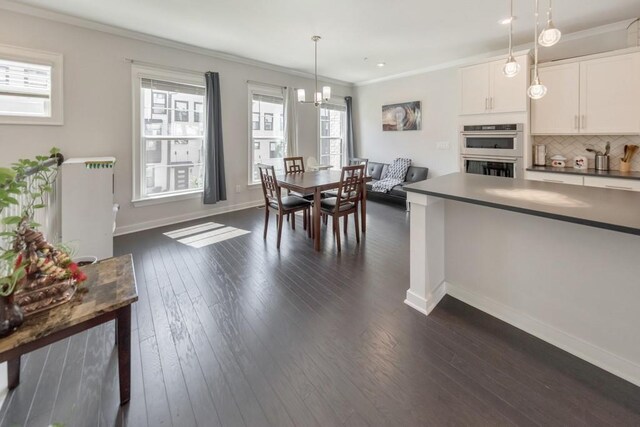 dining room featuring dark wood-type flooring, a chandelier, and crown molding