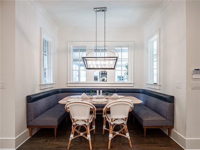 dining space with a notable chandelier, ornamental molding, hardwood / wood-style floors, and a wealth of natural light