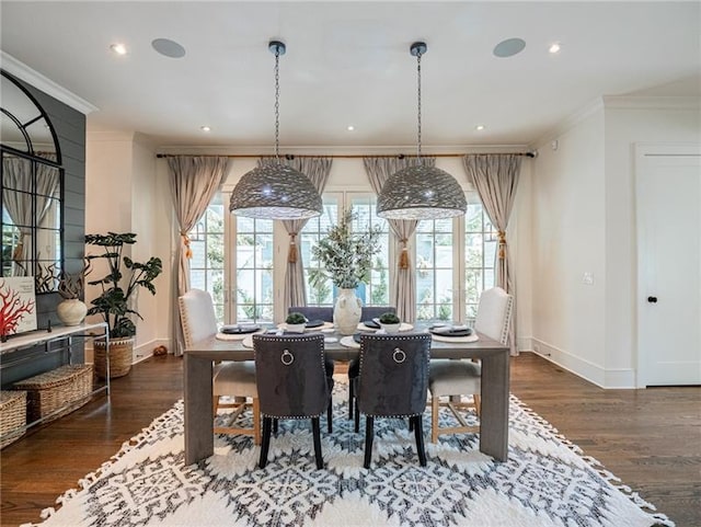 dining area featuring dark wood-type flooring, ornamental molding, and plenty of natural light