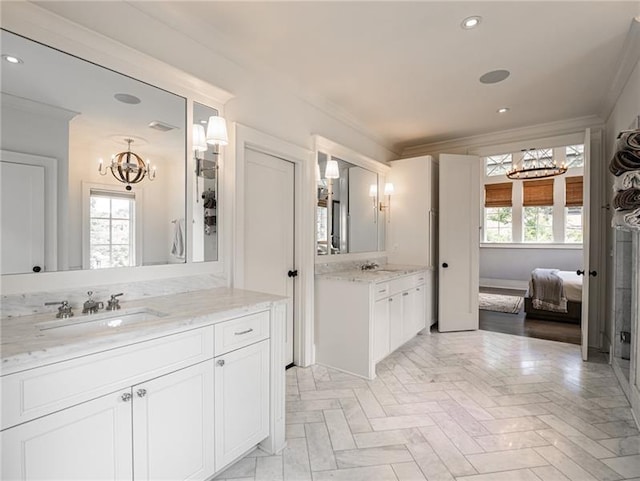 bathroom featuring crown molding, vanity, a chandelier, and parquet floors