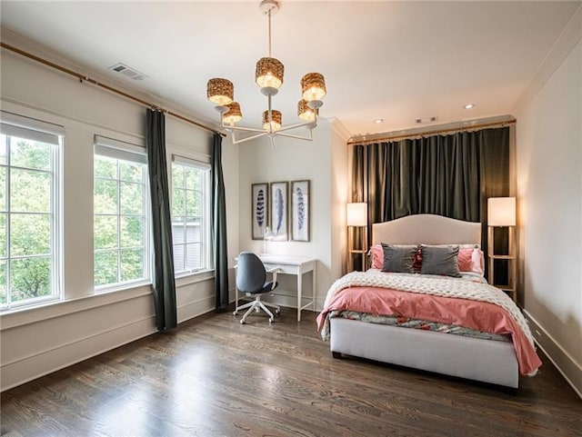 bedroom with a notable chandelier, dark hardwood / wood-style floors, and ornamental molding