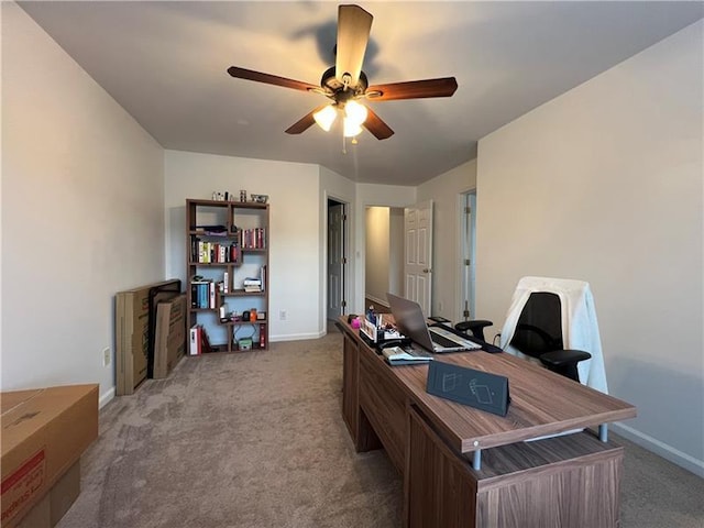 carpeted office space featuring ceiling fan