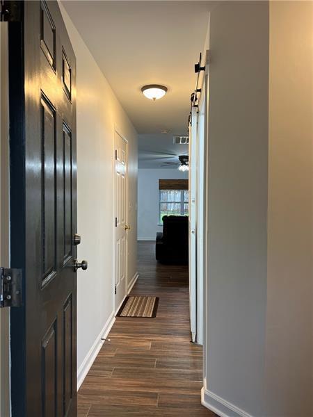 hallway featuring dark hardwood / wood-style floors and a barn door