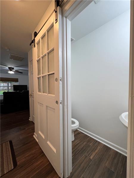 bathroom featuring ceiling fan, wood-type flooring, and toilet