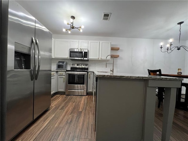 kitchen featuring sink, an inviting chandelier, hanging light fixtures, stainless steel appliances, and white cabinets