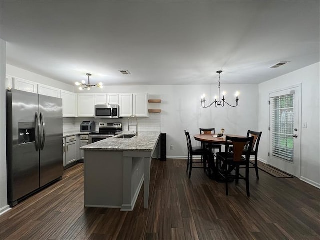 kitchen with sink, kitchen peninsula, a chandelier, and appliances with stainless steel finishes