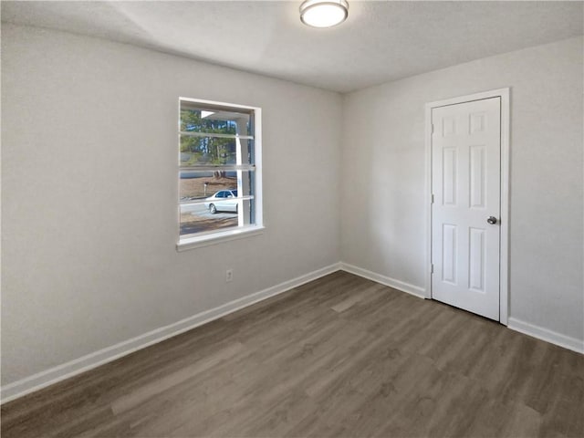 spare room with dark hardwood / wood-style flooring