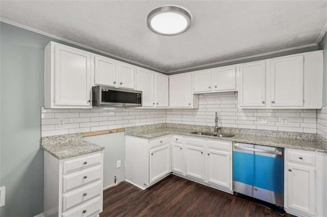 kitchen featuring appliances with stainless steel finishes, dark hardwood / wood-style floors, sink, white cabinets, and light stone countertops