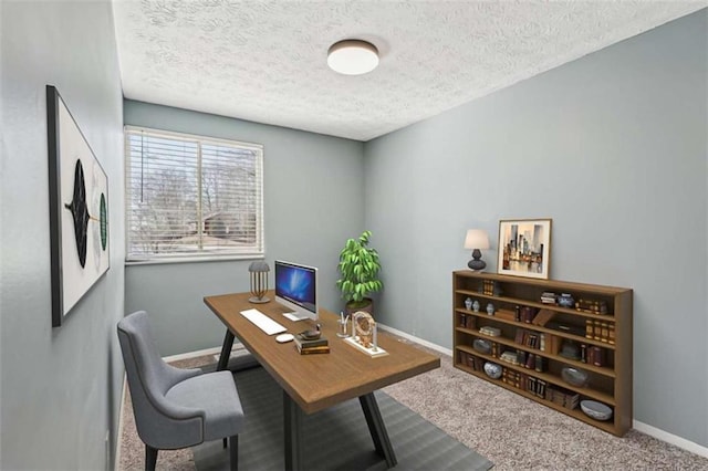 carpeted home office featuring a textured ceiling