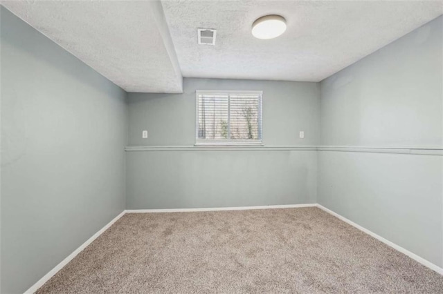 empty room featuring carpet and a textured ceiling