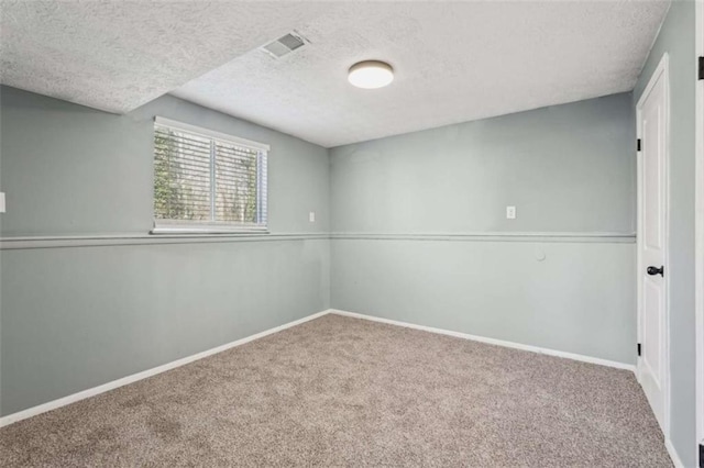 unfurnished room featuring a textured ceiling and carpet