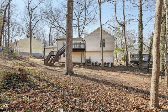 back of house featuring a wooden deck and central air condition unit