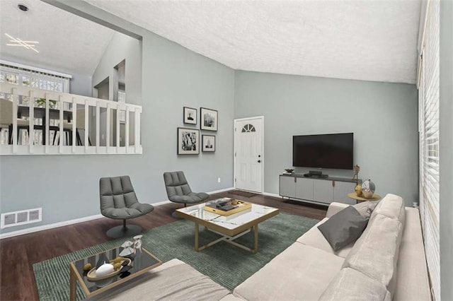 living room featuring hardwood / wood-style flooring, vaulted ceiling, and a textured ceiling