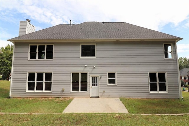 rear view of property featuring a lawn and a patio