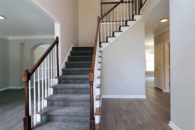 staircase featuring crown molding and wood-type flooring