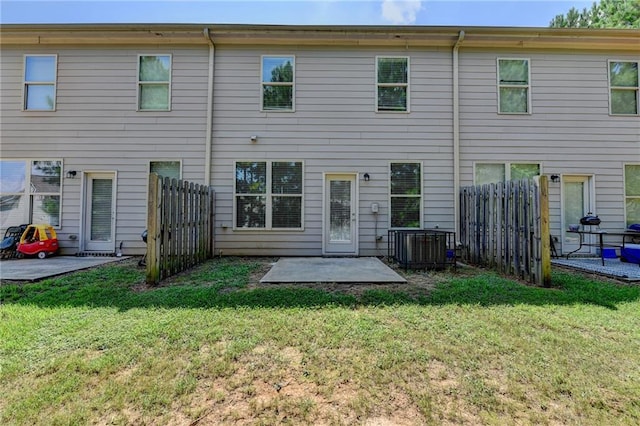 rear view of house with a lawn, a patio area, and central AC unit