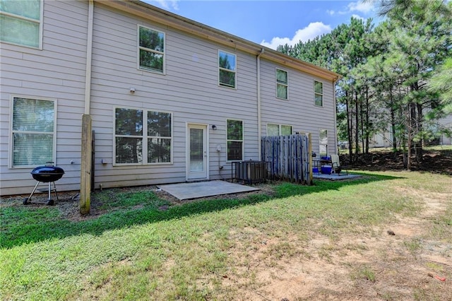 back of house featuring a patio area and a lawn