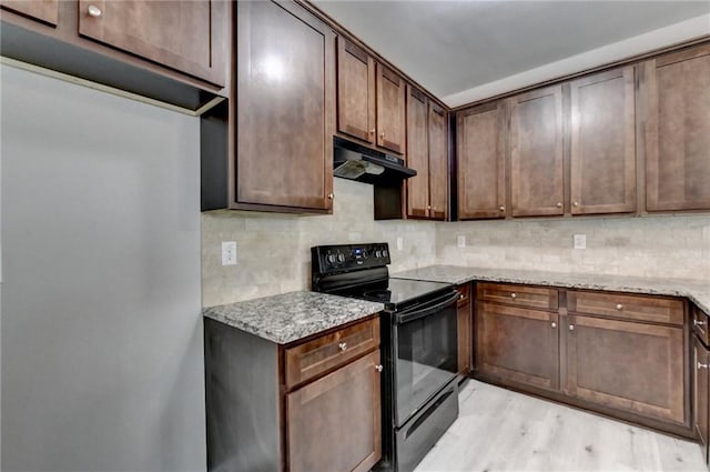 kitchen featuring decorative backsplash, light hardwood / wood-style flooring, black electric range oven, and light stone countertops