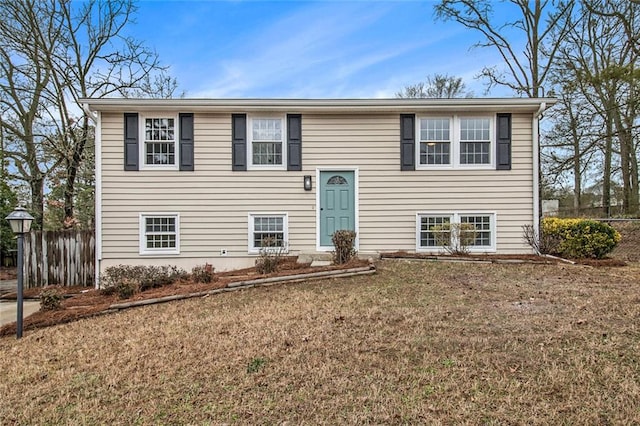 split foyer home with fence and a front lawn