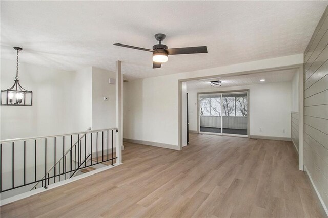 spare room with light wood finished floors, visible vents, baseboards, ceiling fan, and a textured ceiling