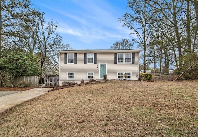 bi-level home featuring a front yard and fence