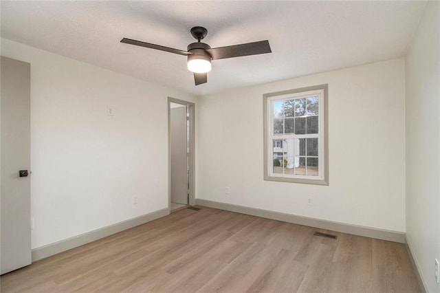 unfurnished room with a ceiling fan, baseboards, visible vents, and light wood finished floors