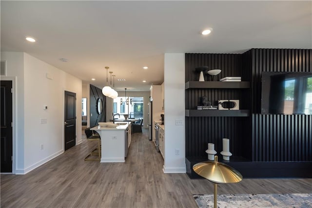 371 Grant Cir Unit 1812, Atlanta, GA 30315 - kitchen with a kitchen island with sink, wood finished floors, light countertops, white cabinetry, and recessed lighting