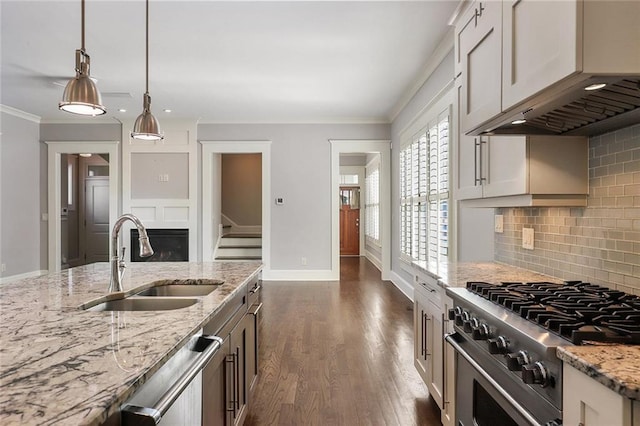 kitchen with hanging light fixtures, backsplash, dark hardwood / wood-style floors, sink, and stainless steel appliances