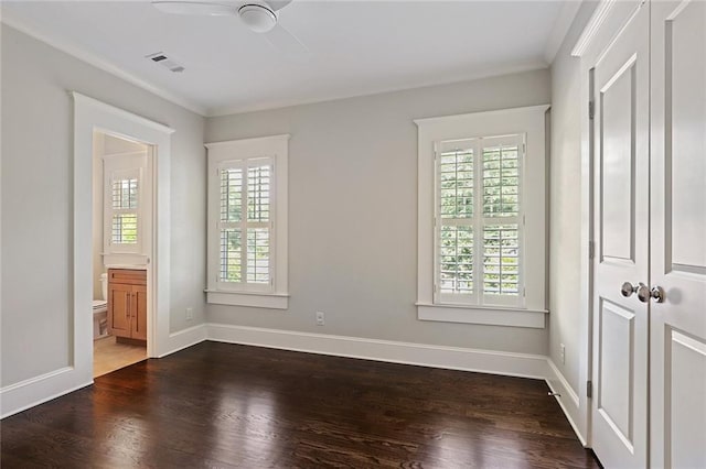 spare room featuring dark hardwood / wood-style floors, ceiling fan, a wealth of natural light, and ornamental molding