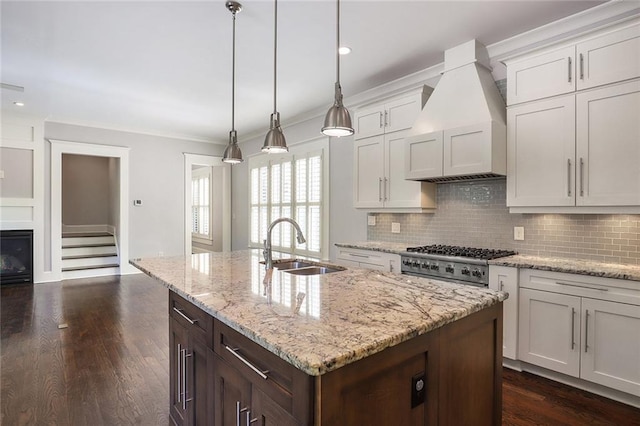 kitchen featuring custom range hood, pendant lighting, tasteful backsplash, ornamental molding, and dark hardwood / wood-style floors