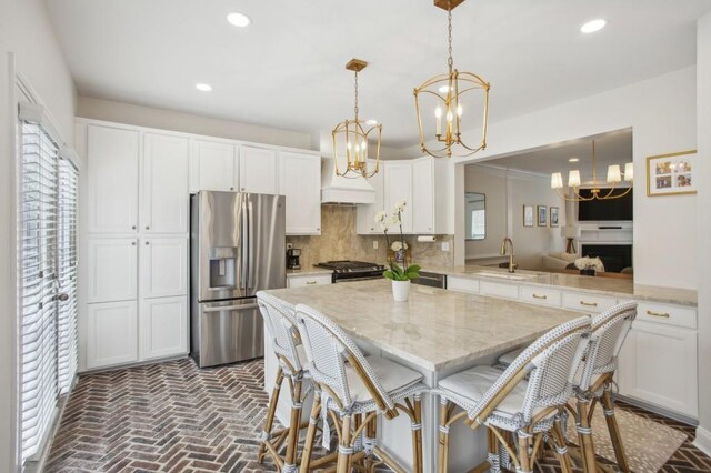 346 Ardmore Ct, Atlanta, GA 30309 - kitchen with recessed lighting, stainless steel appliances, a sink, brick floor, and a chandelier
