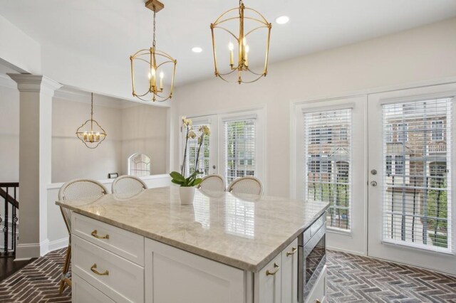 346 Ardmore Ct, Atlanta, GA 30309 - kitchen with white cabinetry, french doors, a chandelier, and brick floor