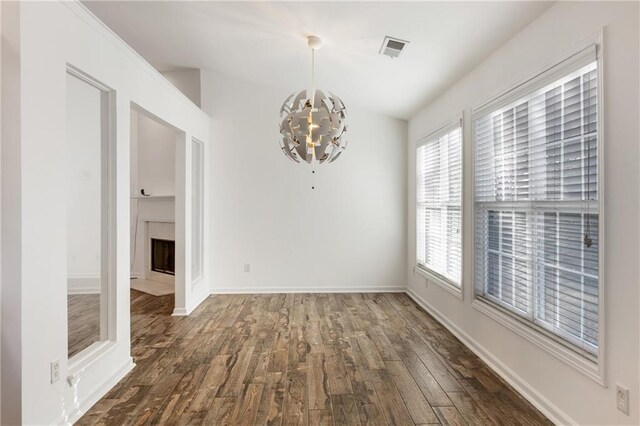 unfurnished dining area with dark hardwood / wood-style flooring and a chandelier