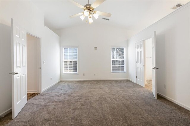 carpeted empty room with high vaulted ceiling and ceiling fan