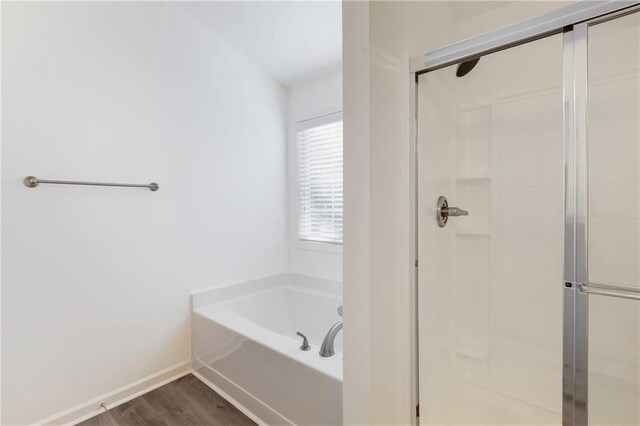 bathroom with wood-type flooring and independent shower and bath