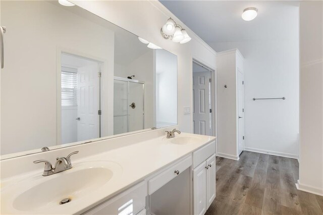 bathroom featuring hardwood / wood-style flooring, vanity, and an enclosed shower