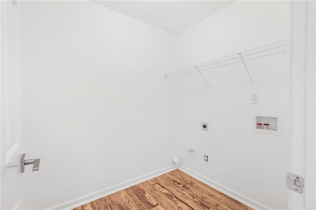 washroom with hookup for an electric dryer, hookup for a gas dryer, hardwood / wood-style flooring, and washer hookup