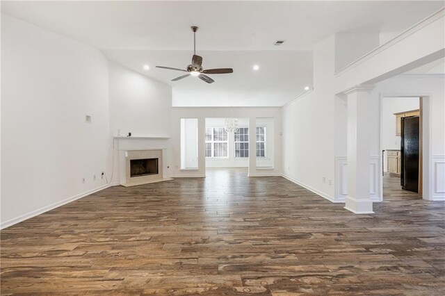 unfurnished living room with a high ceiling, ceiling fan, dark wood-type flooring, and a premium fireplace