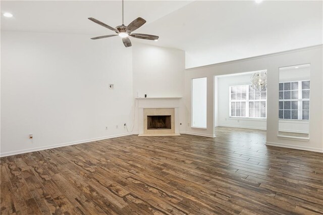 unfurnished living room featuring dark hardwood / wood-style floors, lofted ceiling, and ceiling fan with notable chandelier