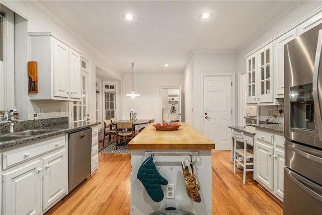 80 Stratford Pl NE, Atlanta, GA 30342 - kitchen featuring appliances with stainless steel finishes, white cabinets, ornamental molding, light wood-style flooring, and recessed lighting