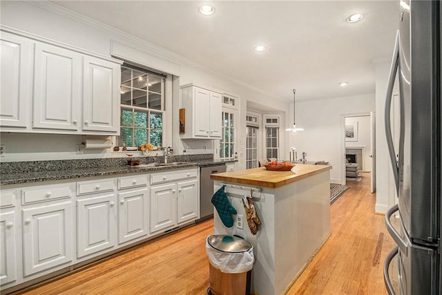 80 Stratford Pl NE, Atlanta, GA 30342 - kitchen with stainless steel appliances, wooden counters, white cabinets, ornamental molding, and recessed lighting